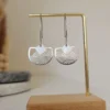 Boucles d’oreilles pendantes ajourées dorées en laiton et acier inoxydable. Fait main, légères et confortables, parfaites pour un look chic et lumineux.