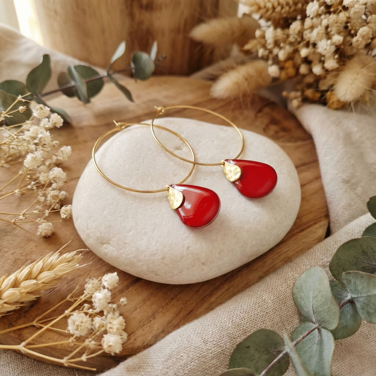 Sans titre (3000 x 3000 px) (46) photo de créoles fines dorées avec pendentif goutte rouge brillant sur rondin de bois