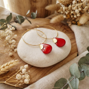 Sans titre (3000 x 3000 px) (46) photo de créoles fines dorées avec pendentif goutte rouge brillant sur rondin de bois