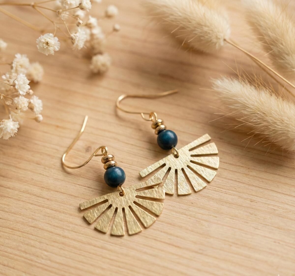 boucles-eventail-dore-hematite-bleue.jpg Boucles d'oreilles éventail doré hématite bleue sur fond bois clair