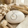 argente-cercle-nacre.jpg Collier court argenté posé sur galet