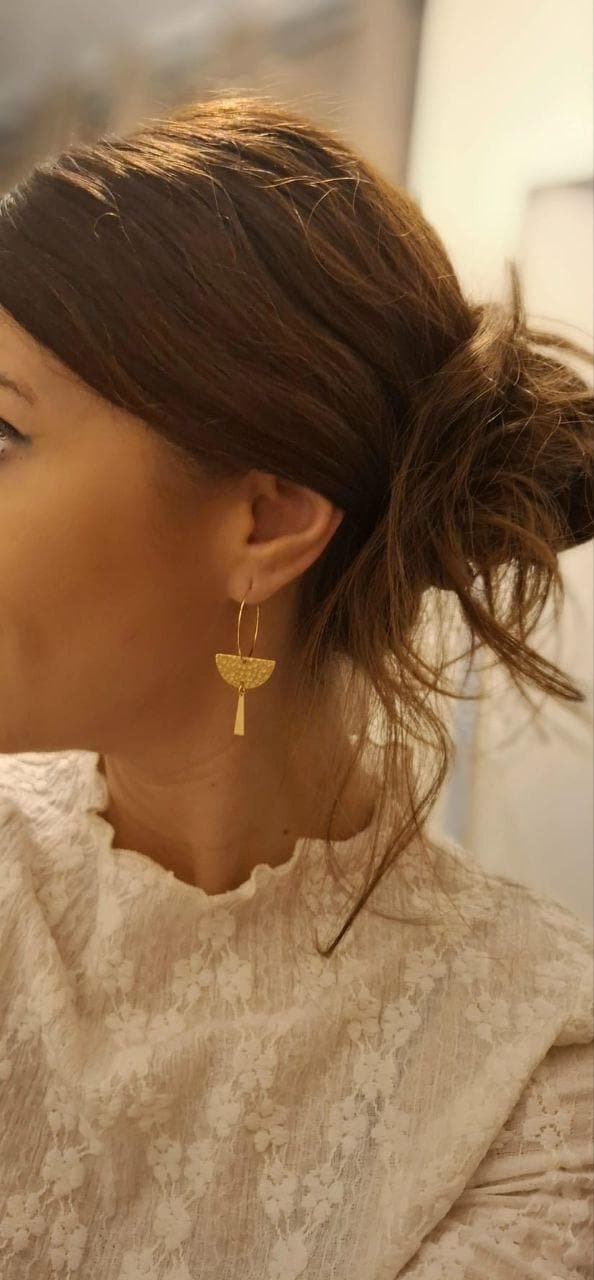 Créoles demi-cercle dorées portées à l'oreille
