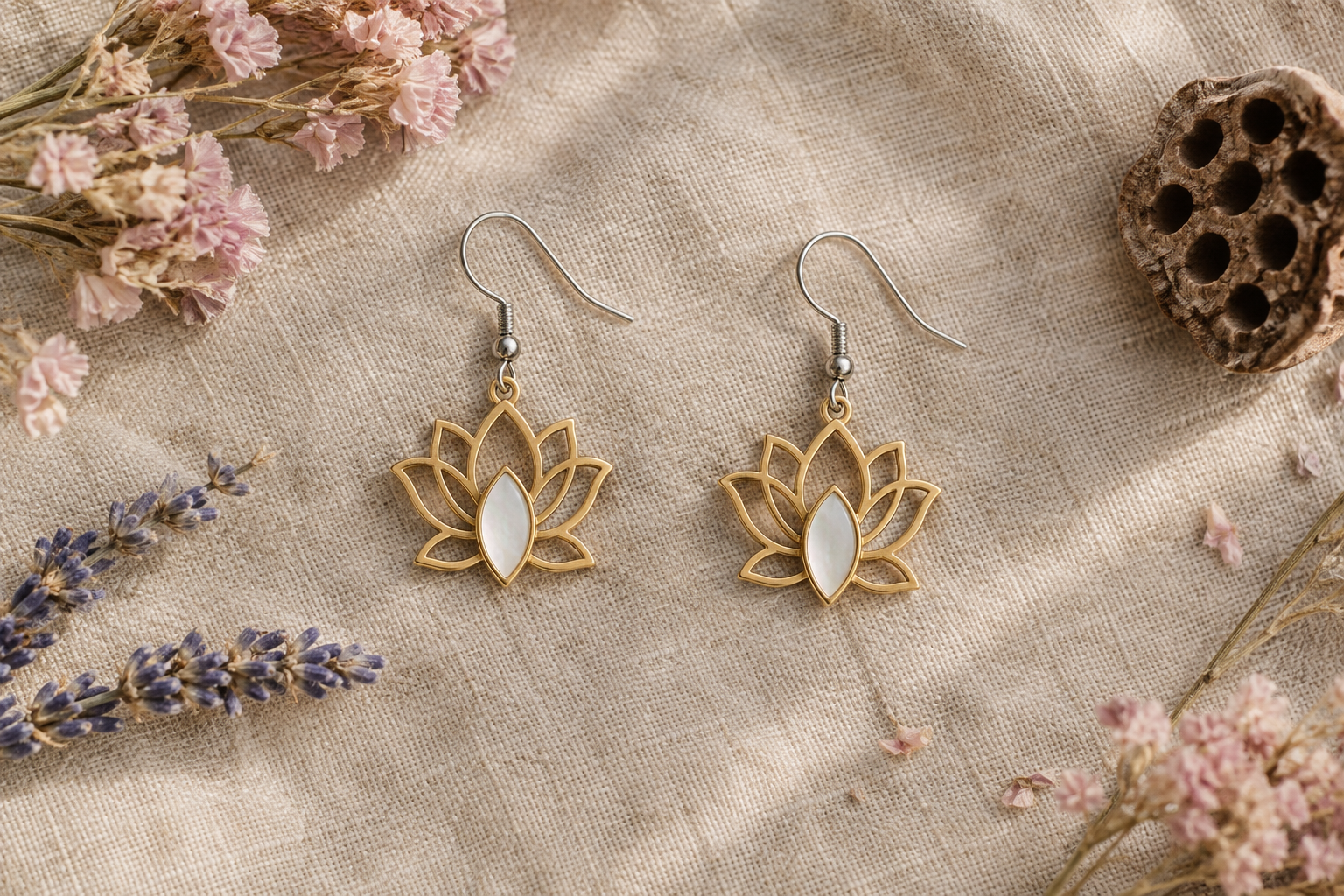 Boucles d’oreilles fleur de lotus dorées et nacre posées sur du lin