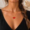 Collier demi-lune rouge porté, chaîne dorée fine