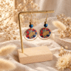 Boucles d'oreilles ginkgo rouge sur présentoir doré – parure ginkgo rouge
