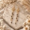 Boucles d'oreilles lotus dorées à chaînes perlées noires