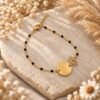 Bracelet lotus doré à chaîne perlée noire et médaille ronde à graver