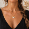 Collier demi-lune blanc nacré porté, chaîne dorée fine
