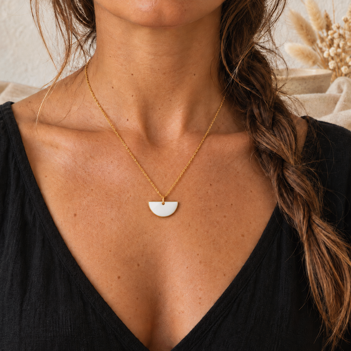 Collier demi-lune blanc nacré porté, chaîne dorée fine
