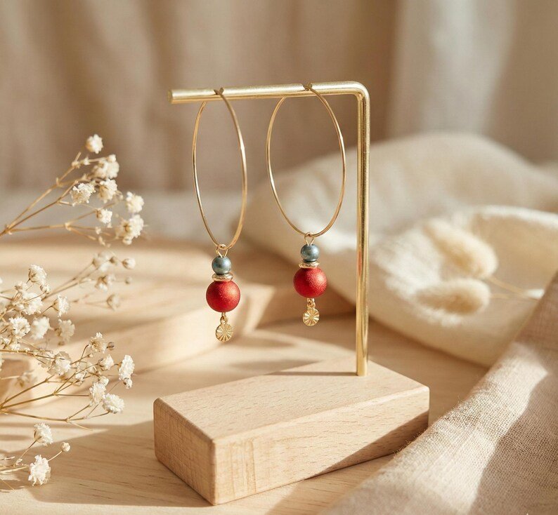 creoles-noel-dorees-perle-rouge Créoles de Noël dorées avec perle rouge satinée et pampille dorée