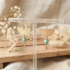 Boucles d'oreilles agate turquoise et demi-cercle en laiton doré martelé sur présentoir